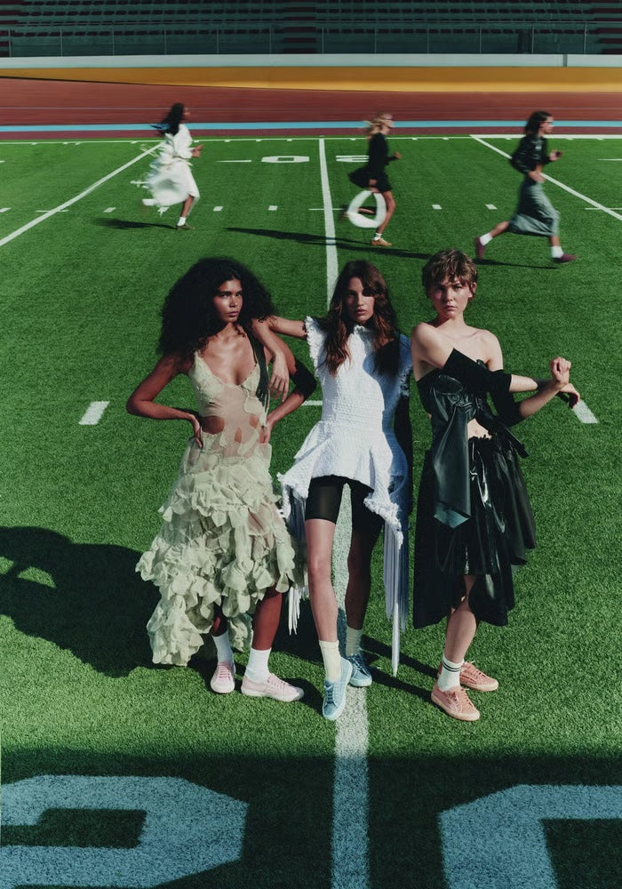 Women in fashion-forward looks on a sports field